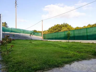 a green fence next to a grass field at Casa Peña Dura in Lalín
