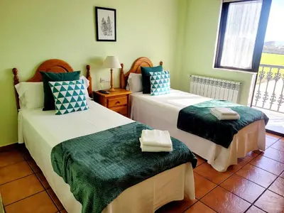 a bedroom with two beds and a window at Vilariño Moscoso in Arzúa