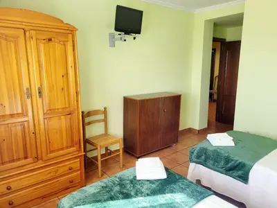 a bedroom with two beds and a tv on the wall at Vilariño Moscoso in Arzúa