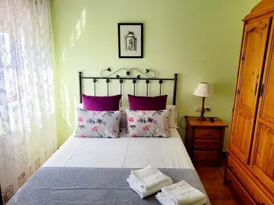 a bedroom with a large bed with purple pillows at Vilariño Moscoso in Arzúa