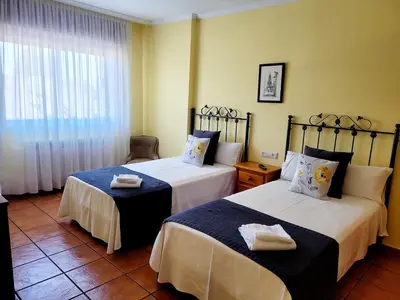 two beds in a room with a window at Vilariño Moscoso in Arzúa