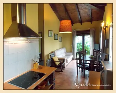a kitchen and living room with a stove top oven at Apartamentos Guidan in Ribadeo