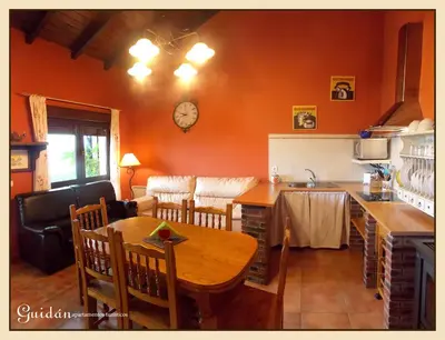 a kitchen and dining room with a table and a kitchen and a table and chairs at Apartamentos Guidan in Ribadeo