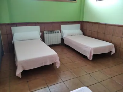 two beds in a room with green walls at A CONDA-habitación privada in Arzúa