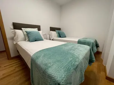 two beds in a room with green and white at Oktheway Pedro Saco Street 2 in Sarria