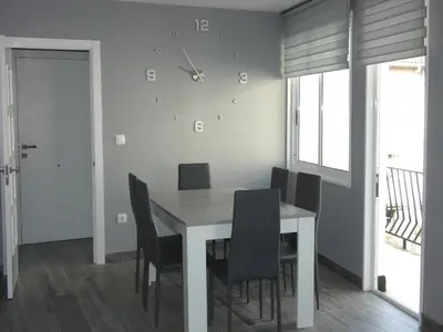 a dining room with a white table and black chairs at O Abeiro do Eume in Puentedeume