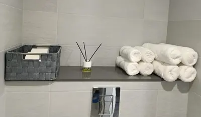 a bunch of towels on a shelf in a bathroom at O Abeiro do Eume in Puentedeume