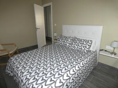 a bedroom with a bed with a black and white comforter at O Abeiro do Eume in Puentedeume