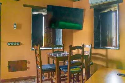 a dining room with a table and chairs and a tv at Casa en zona medieval in Monforte de Lemos