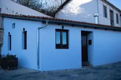 a white garage with a black door on a building at Casa en zona medieval in Monforte de Lemos