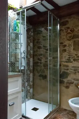 a glass shower in a bathroom with a sink at Casa en zona medieval in Monforte de Lemos