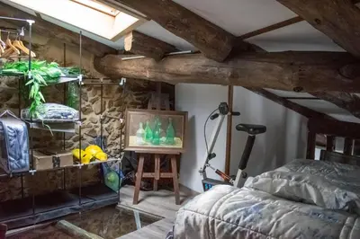 a bedroom with a bed and a stone wall at Casa en zona medieval in Monforte de Lemos
