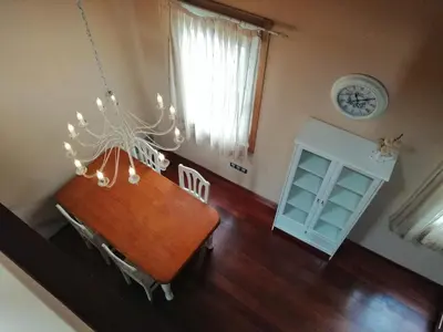 a dining room with a table and a clock on the wall at Apartamentos Turísticos Betanzos in Betanzos