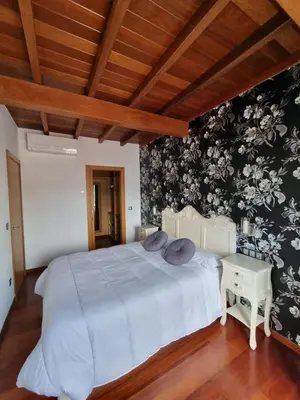a bedroom with a white bed and floral wallpaper at Apartamentos Turísticos Betanzos in Betanzos