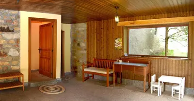 a room with a bench and a desk and a window at Casa Rural Las Verdes l y II in Torre de Babia