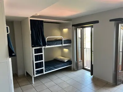 two bunk beds in a room with a window at Albergue San Anton in Melide