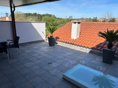 a patio with an orange roof and a tile floor at Albergue San Anton in Melide