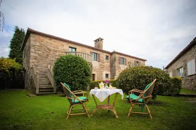 a kitchen with a wooden table and chairs in it at Casa de Barreiro in Teijeiro