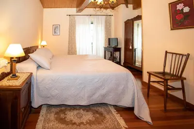 a bedroom with a bed with a television and a night stand at Casa de Barreiro in Teijeiro