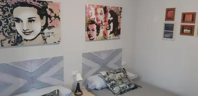 a room with paintings on the wall and a bed at Parque da Ponte in Ourense