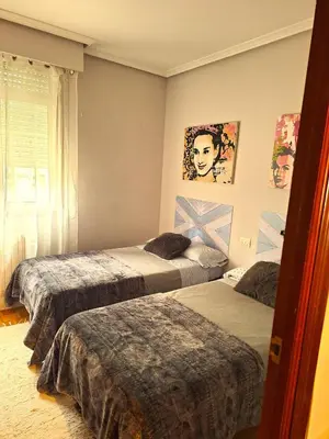 a bedroom with two beds and a window at Parque da Ponte in Ourense