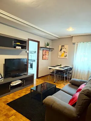 a living room with a couch and a tv and a table at Parque da Ponte in Ourense