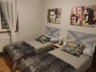 two beds in a room with posters on the wall at Parque da Ponte in Ourense