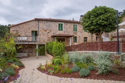 a stone house with a garden in front of it at CASA CON ENCANTO (o Refuxio) in Merza