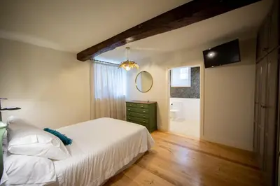 a bedroom with a white bed and a bathroom at CASA CON ENCANTO (o Refuxio) in Merza