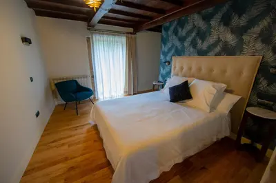 a bedroom with a large white bed and a window at CASA CON ENCANTO (o Refuxio) in Merza