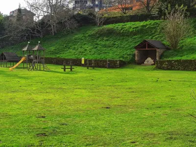 a park with a playground with a slide and a play structure at Indiano 5B in Viveiro