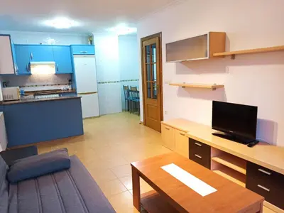 a living room with a table and a kitchen at Indiano 5B in Viveiro