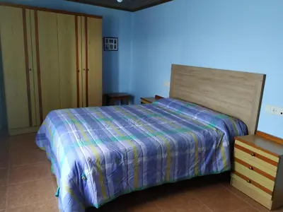 a blue bedroom with a bed and a dresser at Casa Xancin in Ribadeo