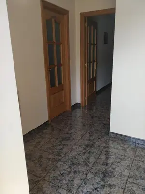 an empty room with two doors and a tile floor at Casa Xancin in Ribadeo