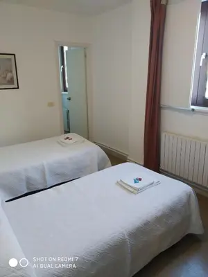a hotel room with two beds and a mirror at Hostal padornelo in Mondoñedo