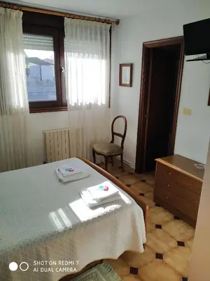 a bedroom with a bed and a chair and a window at Hostal padornelo in Mondoñedo