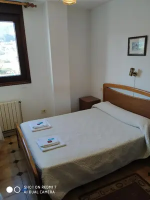 a bedroom with a bed with two towels on it at Hostal padornelo in Mondoñedo