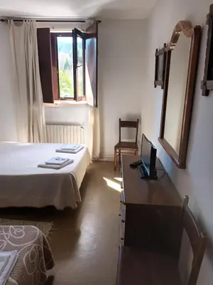 a bedroom with a bed and a desk with a laptop at Hostal padornelo in Mondoñedo