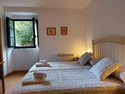 a bedroom with a large bed with two towels on it at Hospedería Externa del Monasterio in Samos