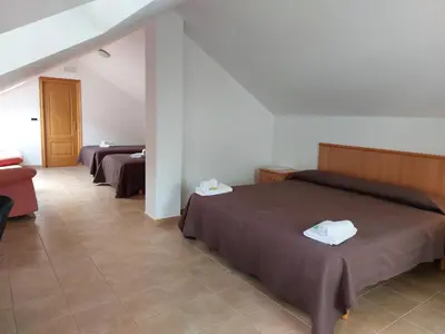 a hotel room with two beds and a couch at Hospedería Externa del Monasterio in Samos
