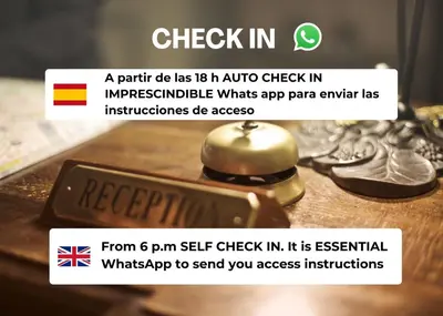 a sign that says check in on a table with a bell at Hospedería Externa del Monasterio in Samos