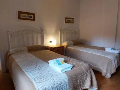 two beds with towels on them in a bedroom at Hospedería Externa del Monasterio in Samos