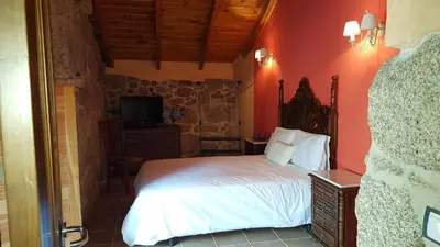a bedroom with a bed and a tv in it at O POMAR VELLO in Pontevedra