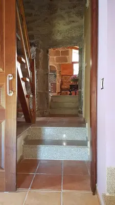 a hallway with stairs leading to a room with a table at O POMAR VELLO in Pontevedra