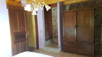 a bedroom with a wooden cabinet and a mirror at O POMAR VELLO in Pontevedra