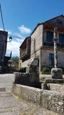 a stone building with a fountain in front of it at O POMAR VELLO in Pontevedra