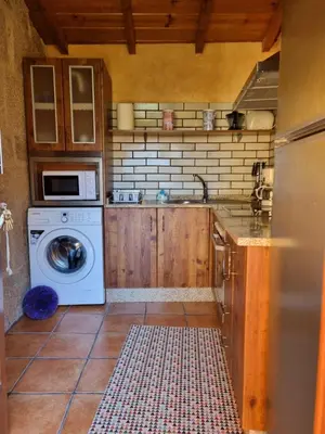 a kitchen with a washing machine and a sink at O POMAR VELLO in Pontevedra