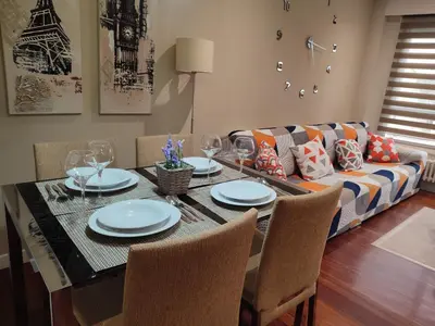 a dining room with a table and a couch at O Fogar de Cati in Ourense