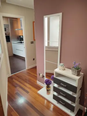 a room with a mirror and a dresser with flowers at O Fogar de Cati in Ourense