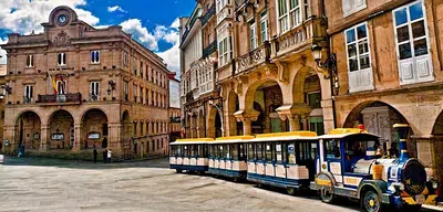 a small bus parked in front of some buildings at O Fogar de Cati in Ourense